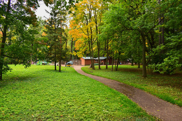 Zoo located in the park. Green leaves on the trees turn yellow from autumn weather.