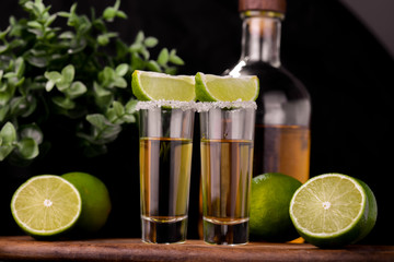 Mexican Gold Tequila with lime and salt on black background with copyspace.