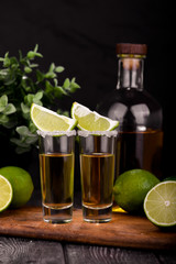 Mexican Gold Tequila with lime and salt on black background with copyspace.