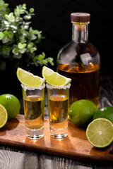 Mexican Gold Tequila with lime and salt on black background with copyspace.