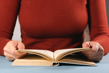 Student reading book close up background.