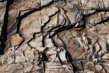 The texture of stone of the rock on a sunny day with the micro shadows