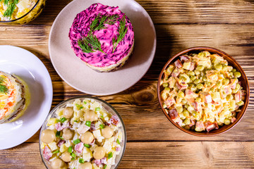 Set of festive mayonnaise salads on wooden table. Top view