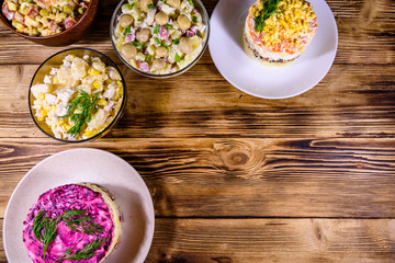 Set of festive mayonnaise salads on wooden table. Top view