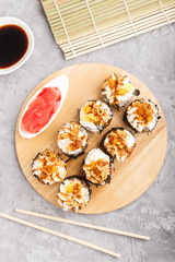 Japanese maki sushi rolls with cream cheese on wooden board on a gray concrete background. Top view.