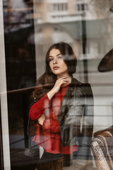 Portrait of beautiful woman, captured through the window glass