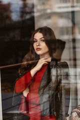 Portrait of beautiful woman, captured through the window glass