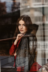 Portrait of beautiful woman, captured through the window glass