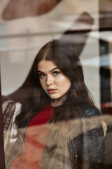 Portrait of beautiful woman, captured through the window glass