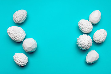 White geometric Easter eggs on turquoise background