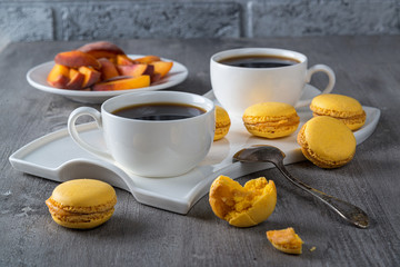 Cup of coffee and  macaroon on an old wooden table.