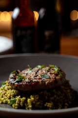 Close up of turkey chop with quinoa on dark blurred background