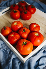 Fresh, pink and red tomatoes on white, different backgrounds and in a wooden crate