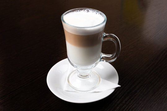 Mug of latte, on a dark, wooden background.