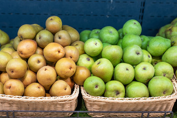 Yellow and green pears on a shelf of the refrigerator, in a supermarket.