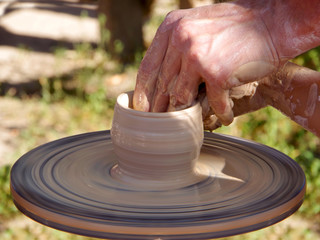 Making dishes from clay on a potter's wheel.