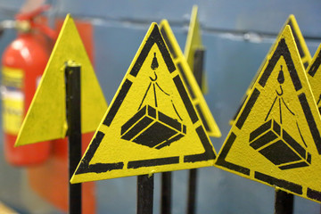 Caution. Lifting and moving heavy goods. Yellow triangular warning sign