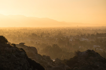 Hazy morning sunshine above West San Fernando Valley neighborhoods in the city of Los Angeles, California.  The San Gabriel Mountains are in the background.