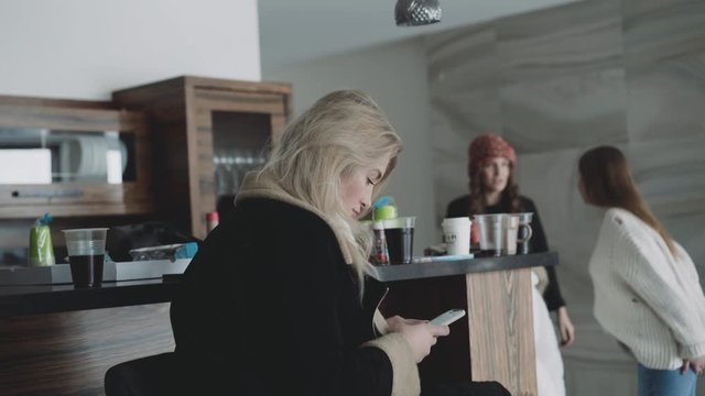 The girl using smartphone in room at other friends background