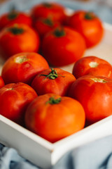 Fresh, pink and red tomatoes on white, different backgrounds and in a wooden crate