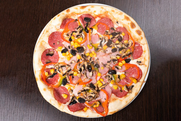 Pizza with pepperoni and mushrooms, ham and sweet pepper.