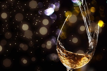 White wine being poured in wineglass, closeup