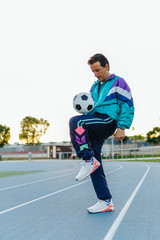 Adult sportsman man playing with soccer ball, training with vintage sportswear