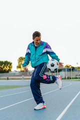 Adult sportsman man playing with soccer ball, training with vintage sportswear