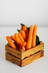 Carrots in wooden crate and green beans in glass