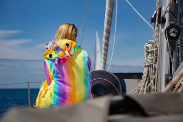 Dziewczyna w tęczowej pidżamie na pokładzie łodzi - obrazy, fototapety, plakaty