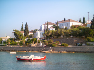 Fototapeta na wymiar Smail boat anchored below island houses