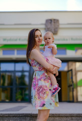 Happy mother and daughter in the park. Beauty nature scene with family outdoor lifestyle. Happy family resting together on the green grass, having fun outdoor. Happiness and harmony in family life