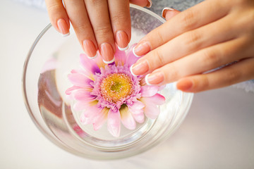 Obraz na płótnie Canvas Beautiful woman's nails with french manicure, in beauty studio