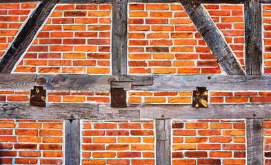 Old half-timbered made wooden with old red bricks as background.