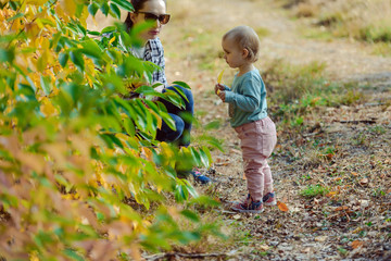 happy family mother and child little daughter running and playing on autumn walk