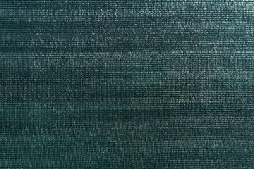 Dark green knitted polyethylene mesh background. Agro sun shade net textured surface sample....