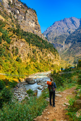 Male trekker from behind in rocky valley in Himalaya mountains in Nepal.