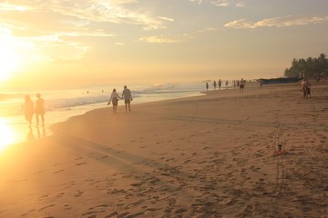 Incredible sunset on the ocean, sun, yellow colors. People walking and relax