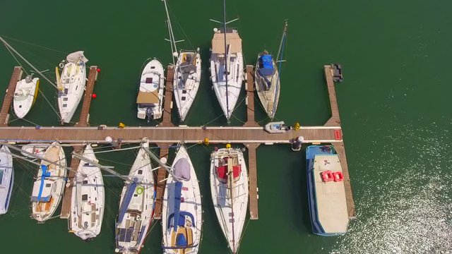 Aerial, tilt up, drone shot, reversing over sailboats and yachts, revealing the Olhao marina, on a sunny day, in Algarve, Portugal