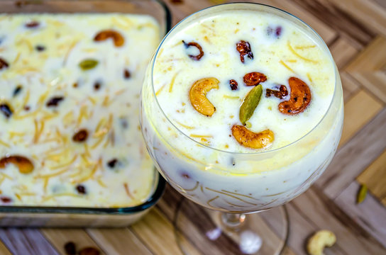 Closeup of Vermicelli Kheer in a Balloon Glass garnished with Cashew, raisins & cardamom.