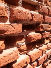 Ancient and genuine wall. Solid red clay brick very old. The wall where the long brick is preserved and the assembly and junction material is eroded. Patches of adobe and white varied chunks. Reddish.