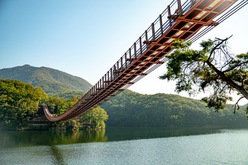 Suspension bridge connected to the mountain across the lake