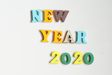 Colourful New Year 2020 wording  made of wooden alphabet letter on white background.