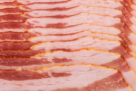 Background of bacon slices disposed in a line and directly above. Close up.