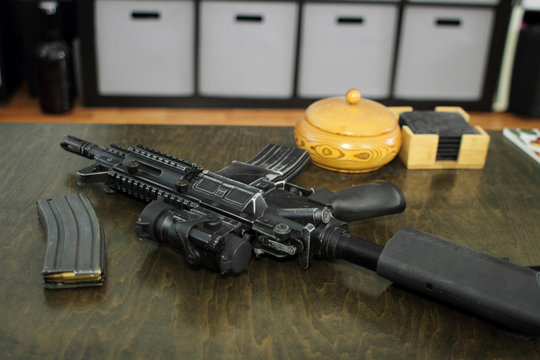 High capacity magazine with bullets next to an AR15 on a table in a home.