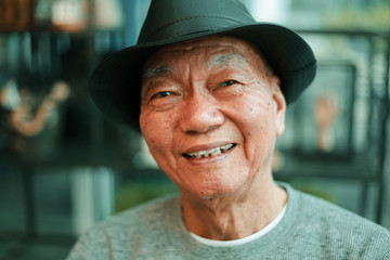 Asian senior man drinking coffee in coffee shop cafe