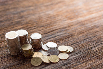 Stack of Thai coins on wood background and copy space  with warm light