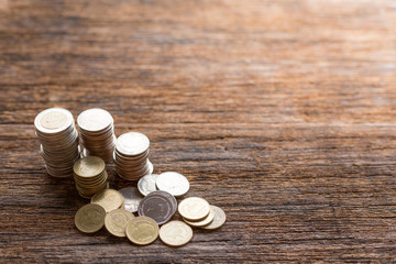 Stack of Thai coins on wood background and copy space  with warm light
