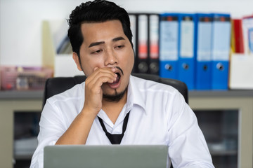 Obraz premium tired businessman using laptop and yawning