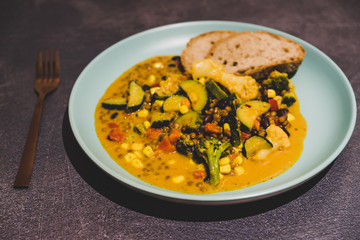 healthy vegan lentil soup with mixed veggies in curry sauce and bread